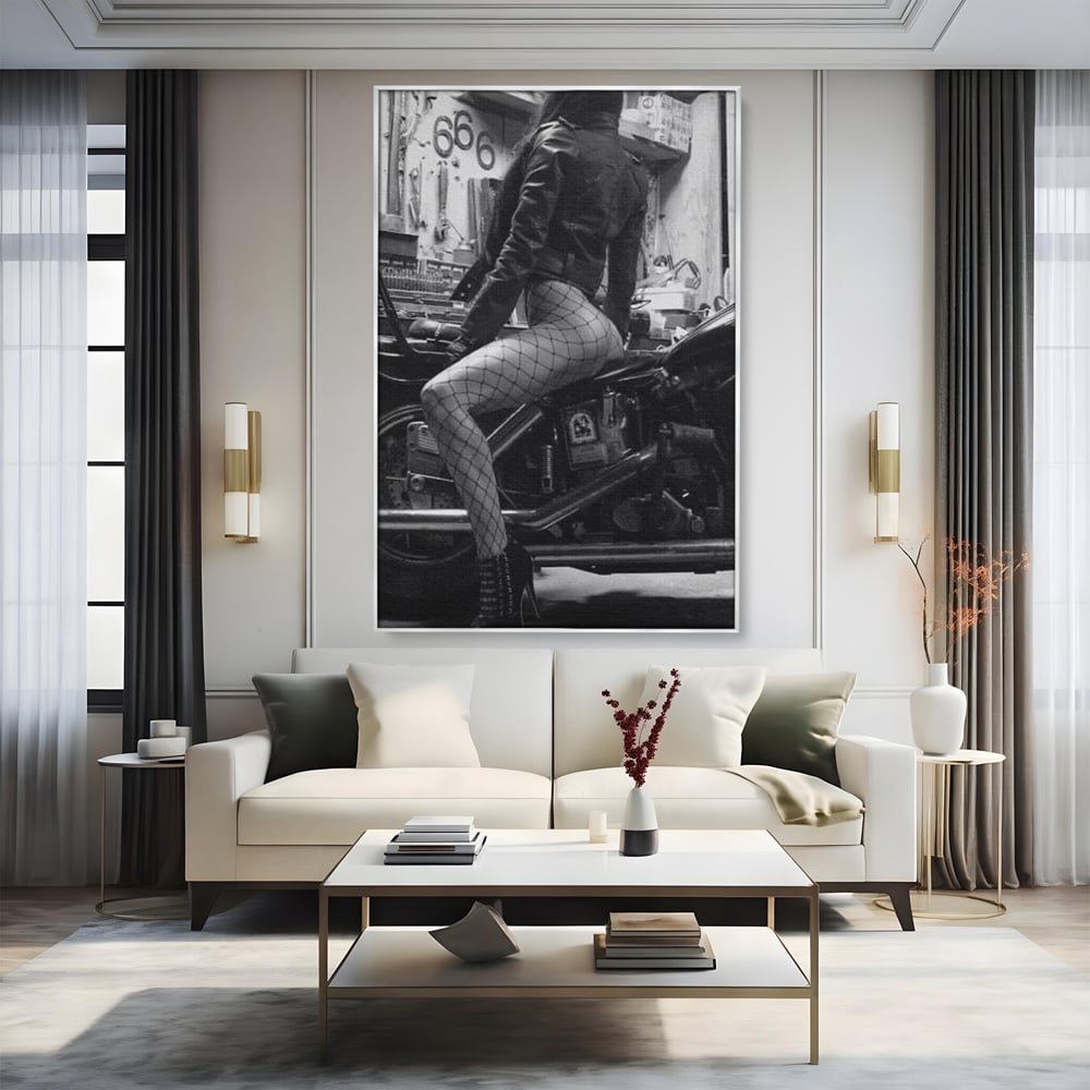 Tablou canvas cu tablou canvas cu femeie pe motocicleta, in rama de aluminiu argintiu, pe perete intr-un living